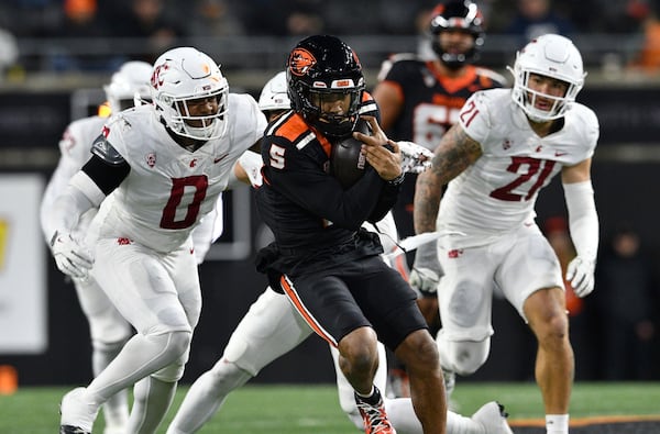 Washington State linebacker Taariq Al-Uqdah (0) pursues Oregon State quarterback Gabarri Johnson (5) during the first half of an NCAA college football game Saturday, Nov. 23, 2024, in Corvallis, Ore. (AP Photo/Mark Ylen)