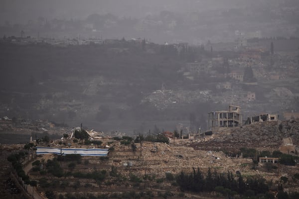 An Israeli flag stands next to destroyed buildings on an area in southern Lebanon as seen from northern Israel, Monday, Nov. 25, 2024. (AP Photo/Leo Correa)