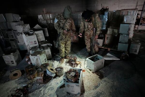 Syrian members of the rebel group inspecting electrical components that were used to hide amphetamine pills known as Captagon hidden at the warehouse where the drug was manufactured before the fall of Bashar Assad government at a facility in Douma city, outskirts of Damascus, Syria, Friday, Dec. 13, 2024. (AP Photo/Hussein Malla)