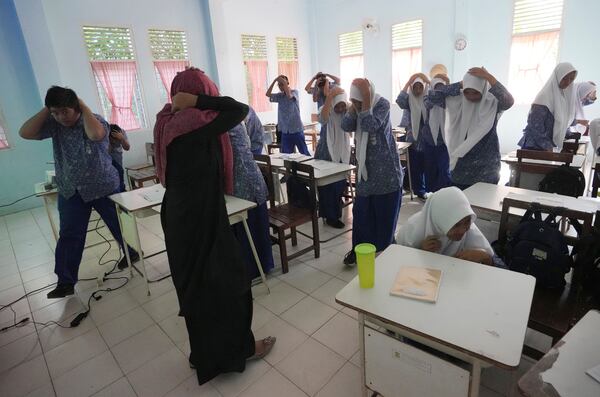 Students take part in an earthquake drill at a school in Banda Aceh, Indonesia, Thursday, Dec. 12, 2024. (AP Photo/Achmad Ibrahim)