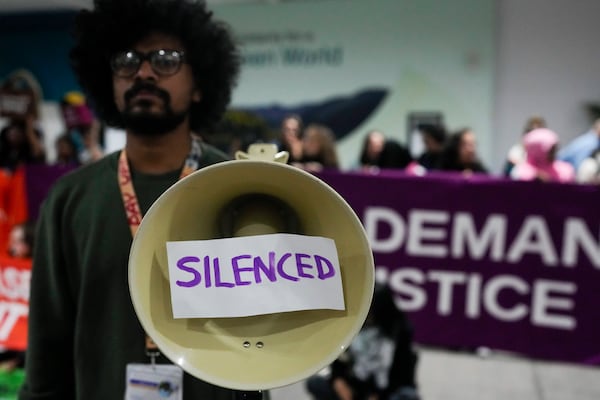 An activist holds a megaphone that says silenced during a demonstration at the COP29 U.N. Climate Summit, Saturday, Nov. 16, 2024, in Baku, Azerbaijan. (AP Photo/Rafiq Maqbool)