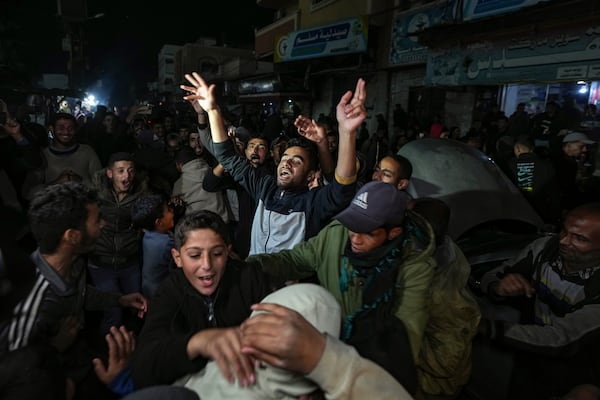 Palestinians celebrate the announcement of a ceasefire deal between Hamas and Israel in Deir al-Balah, central Gaza Strip, Wednesday, Jan. 15, 2025. (AP Photo/Abdel Kareem Hana)