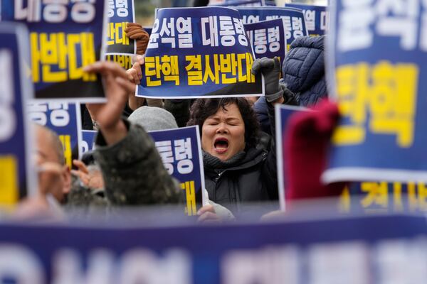 A supporter for impeached South Korean President Yoon Suk Yeol shouts slogans during a rally against his impeachment near the Constitutional Court in Seoul, South Korea, Friday, Dec. 20, 2024. The signs read "Oppose the impeachment of President Yoon Suk Yeol." (AP Photo/Ahn Young-joon)