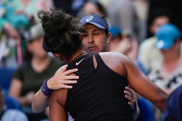 Naomi Osaka of Japan is embraced by Belinda Bencic, right, of Switzerland after she retired from their third round match at the Australian Open tennis championship in Melbourne, Australia, Friday, Jan. 17, 2025. (AP Photo/Manish Swarup)