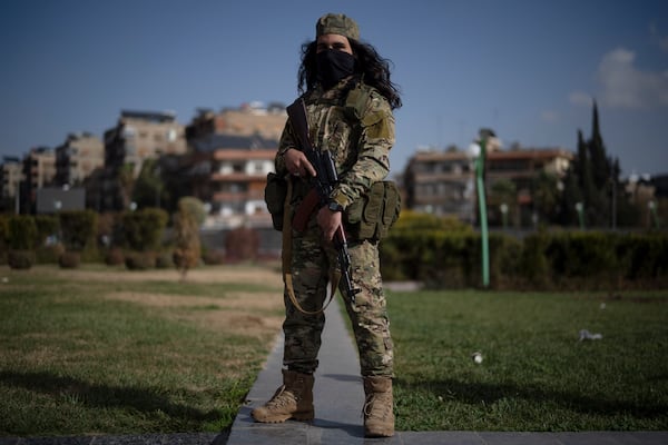 A member of the new armed forces, former rebel who took part in the overthrow of Bashar Assad's government and now serves in the new Syrian government, poses for a picture as he stands at a square before a military parade in Damascus, Syria, Friday, Dec. 27, 2024. (AP Photo/Leo Correa)