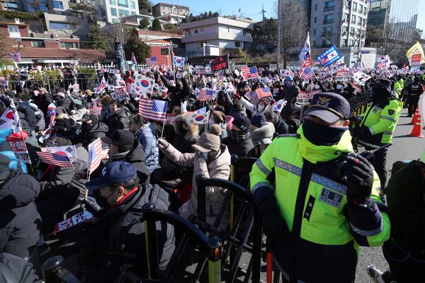 Supporters of impeached South Korean President Yoon Suk Yeol stage a rally after hearing a news that a court issued warrants to detain Yoon, near the presidential residence in Seoul, South Korea, Tuesday, Dec. 31, 2024. (AP Photo/Lee Jin-man)