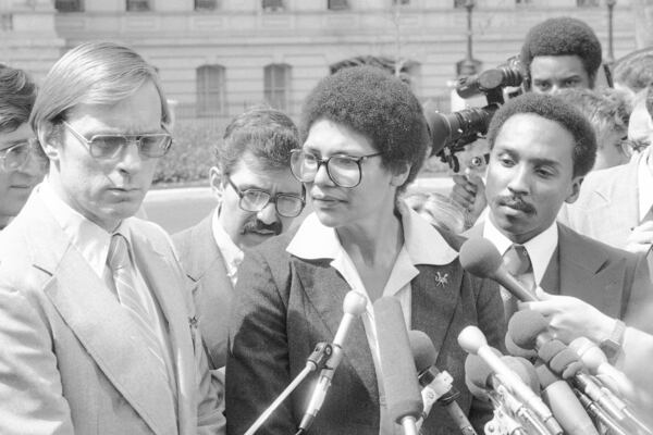 FILE - Anita DeFrantz, spokeswoman for the U.S. Olympic Committee's Athletes Advisory Council, flanked by Larry Hough, left, and Fred Newhouse right, answers questions from reporters outside the White House in Washington on April 4, 1980, after White House officials rejected a proposal that would have allowed American athletes to compete at the summer Olympic Games in Moscow. (AP Photo, File)