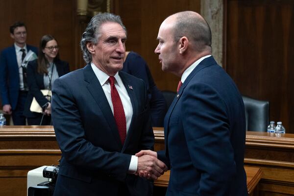 Former Gov. Doug Burgum, President-elect Donald Trump's choice to lead the Interior Department as Secretary of the Interior, shakes hands with Sen. Mike Lee, R-Utah Chairman of the Senate Energy and Natural Resources Committee on Capitol Hill in Washington, Thursday, Jan. 16, 2025. (AP Photo/Jose Luis Magana)