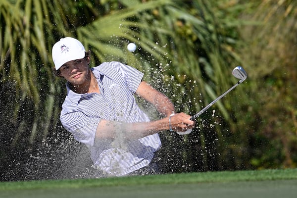 Charlie Woods hits out of a bunker onto the fourth green during the first round of the PNC Championship golf tournament, Saturday, Dec. 21, 2024 in Orlando. (AP Photo/Phelan M. Ebenhack)