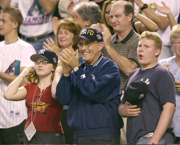 FILE -New York Mayor Rudy Giuliani, center, is flanked by his son, Andrew, right, and Caren Barbara, daughter of New York City Assistant Deputy Fire Chief Gerard A. Barbara, who was killed in the World Trade Center attack. (AP Photo/David J. Phillip, File)