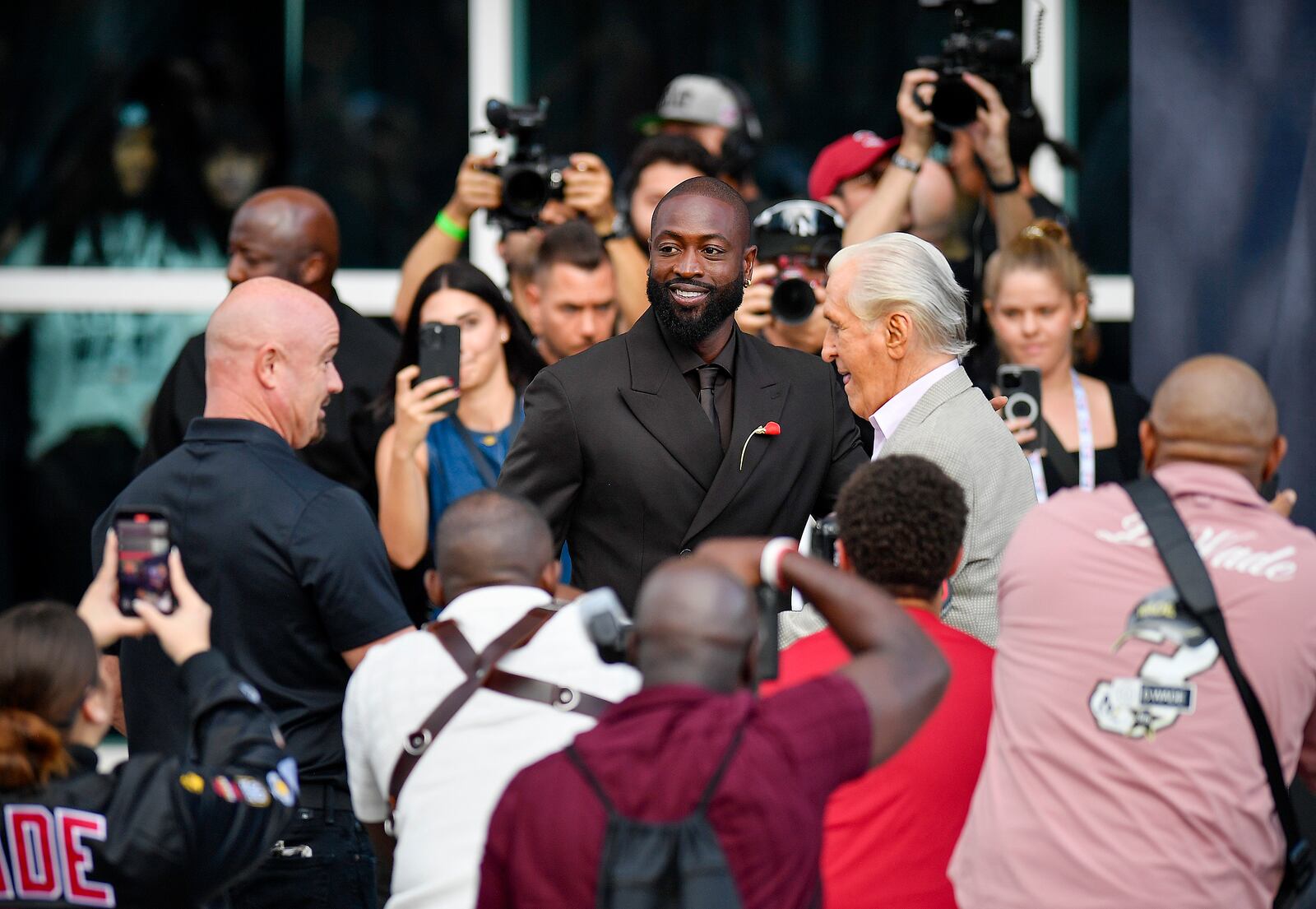 Former Miami Heat NBA basketball player Dwyane Wade, center, arrives at his statue unveiling ceremony outside Kaseya Center, Sunday, Oct. 27, 2024, in Miami, Fla. (AP Photo/Michael Laughlin)