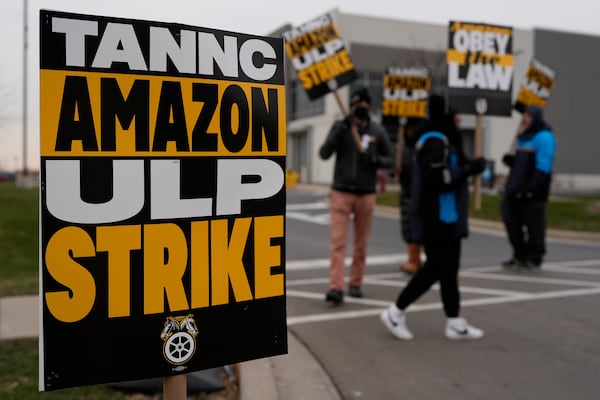 Strikers hold signs during a strike at Skokie (DIL7) Amazon Delivery station in Skokie, Ill., Thursday, Dec. 19, 2024. (AP Photo/Nam Y. Huh)