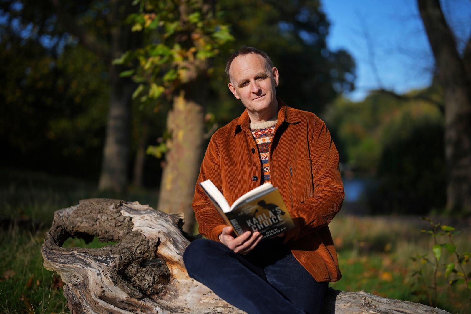 British author Nick Harkaway, son of John le Carre, poses for a photograph a copy of his book, during an interview with The Associated Press, at his home, in London, Thursday, Oct. 24, 2024. (AP Photo/Kin Cheung)