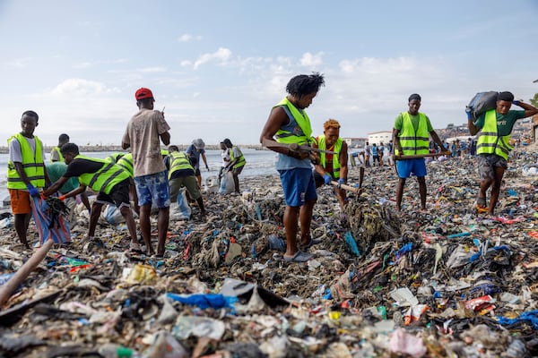 Volunteers and workers for the OR Foundation partake in a beach clean up at Jamestown in Accra, Ghana, Saturday, Oct. 19, 2024. (AP Photo/Misper Apawu)