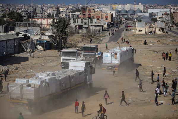 Humanitarian aid trucks enter through the Kerem Shalom crossing from Egypt into the Gaza Strip, as a ceasefire deal between Israel and Hamas went into effect, in Rafah, Tuesday, Jan. 21, 2025. (AP Photo/Jehad Alshrafi)