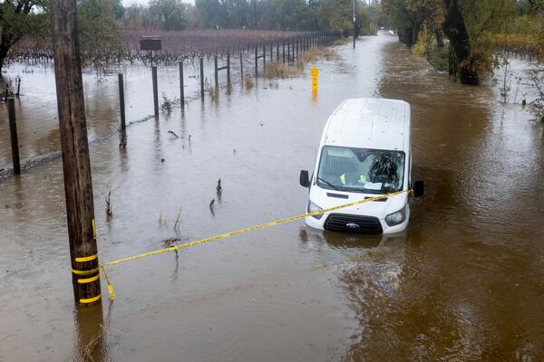 Floodwaters surround a van as heavy rains fall in Windsor, Calif., on Friday, Nov. 22, 2024. (AP Photo/Noah Berger)