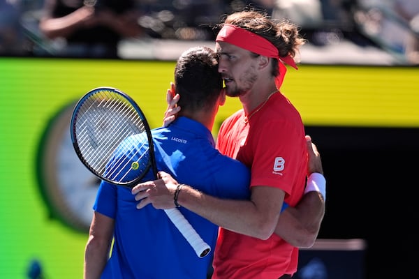 Alexander Zverev, right, of Germany embraces Novak Djokovic of Serbia after Djokovic retired from their semifinal match at the Australian Open tennis championship in Melbourne, Australia, Friday, Jan. 24, 2025. (AP Photo/Ng Han Guan)