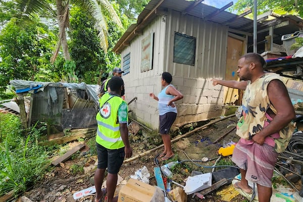 In this photo released by Vanuatu Red Cross Society, Red Cross volunteers assist locals as they inspect their damaged house in Efate, Vanuatu, Thursday, Dec. 19, 2024, following a powerful earthquake that struck just off the coast of Vanuatu in the South Pacific Ocean. (Vanuatu Red Cross Society via AP)