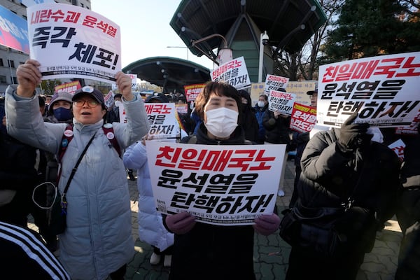 Members of main opposition Democratic Party stage a rally against South Korean President Yoon Suk Yeol in front of the National Assembly in Seoul, South Korea, Wednesday, Dec. 4, 2024. The signs read "Let's impeach Yoon Suk Yeol ." (AP Photo/Ahn Young-joon)