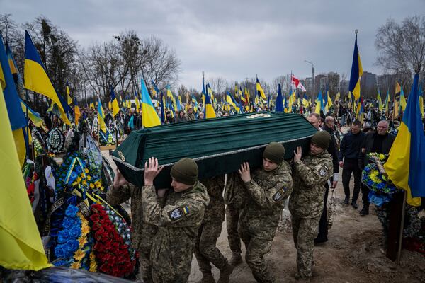 FILE - Ukrainian servicemen carry the coffin of their comrade, Andrii Neshodovskiy, at a cemetery in Kyiv, Ukraine, on March 25, 2023. (AP Photo/Evgeniy Maloletka, File)