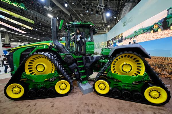 A convention goer exits a John Deere 9RX Tractor at the John Deere booth during the CES tech show Tuesday, Jan. 7, 2025, in Las Vegas. (AP Photo/John Locher)