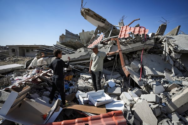 Murad Muqdad, center, stands amid the rubble of his destroyed home, in Rafah, southern Gaza Strip, Tuesday, Jan. 21, 2025, days after the ceasefire deal between Israel and Hamas came into effect. (AP Photo/Abdel Kareem Hana)