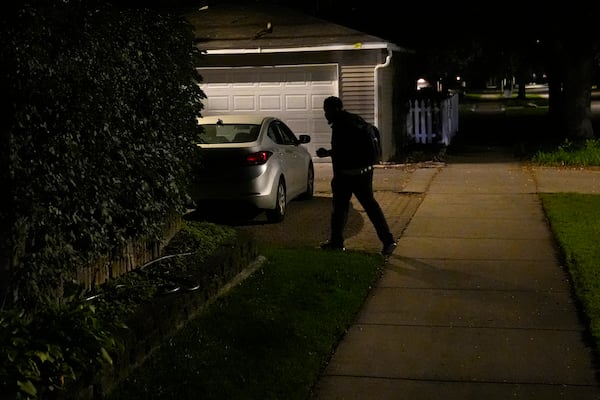 PiggyBack Network, co-founder and CEO Ismael El-Amin heads to his car in the pre-dawn hours of Friday, Oct. 18, 2024, where he will begin to help drive two children to school as part of the PiggyBack ride-share network in Chicago. (AP Photo/Charles Rex Arbogast)