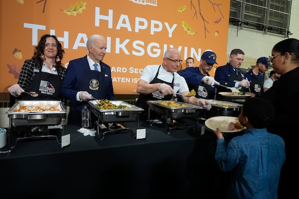 President Joe Biden, from second left, and chef Robert Irvine serve food at a Friendsgiving event with service members and their families in the Staten Island borough of New York, Monday, Nov. 25 2024. (AP Photo/Manuel Balce Ceneta)