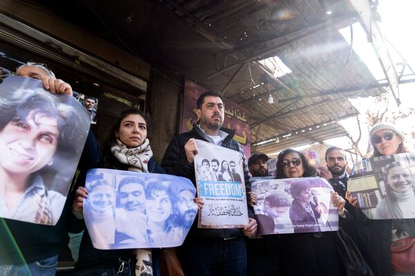 Activists and relatives take part in a protest demanding the whereabouts of four activists who disappeared during the war between opposition groups and former President Bashar Assad's forces, in Douma, Syria, Wednesday, Jan. 1, 2025. (AP Photo/Mosa'ab Elshamy)