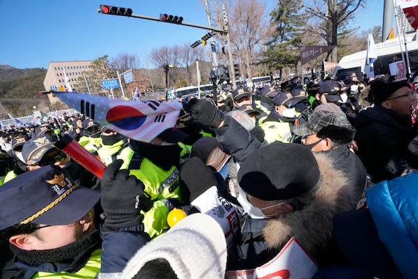 Supporters of impeached South Korean President Yoon Suk Yeol struggle with police officers during a rally to oppose his impeachment near the Corruption Investigation Office for High-Ranking Officials in Gwacheon, South Korea, Wednesday, Jan. 15, 2025. (AP Photo/Ahn Young-joon)