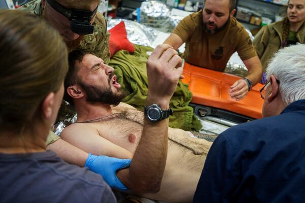 FILE - Ukrainian military medics of the Azov brigade move an injured comrade on a stretcher, at the stabilization point near Toretsk, Donetsk region, Ukraine, Tuesday, Sept. 24, 2024. (AP Photo/Evgeniy Maloletka, File)