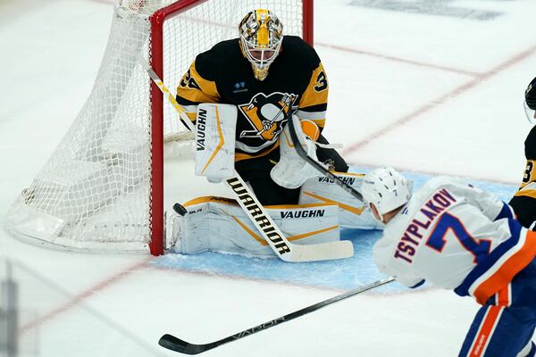 Pittsburgh Penguins goaltender Alex Nedeljkovic stops a shot by New York Islanders' Maxim Tsyplakov (7) during the first period of an NHL hockey game, Sunday, Dec. 29, 2024, in Pittsburgh. (AP Photo/Matt Freed)