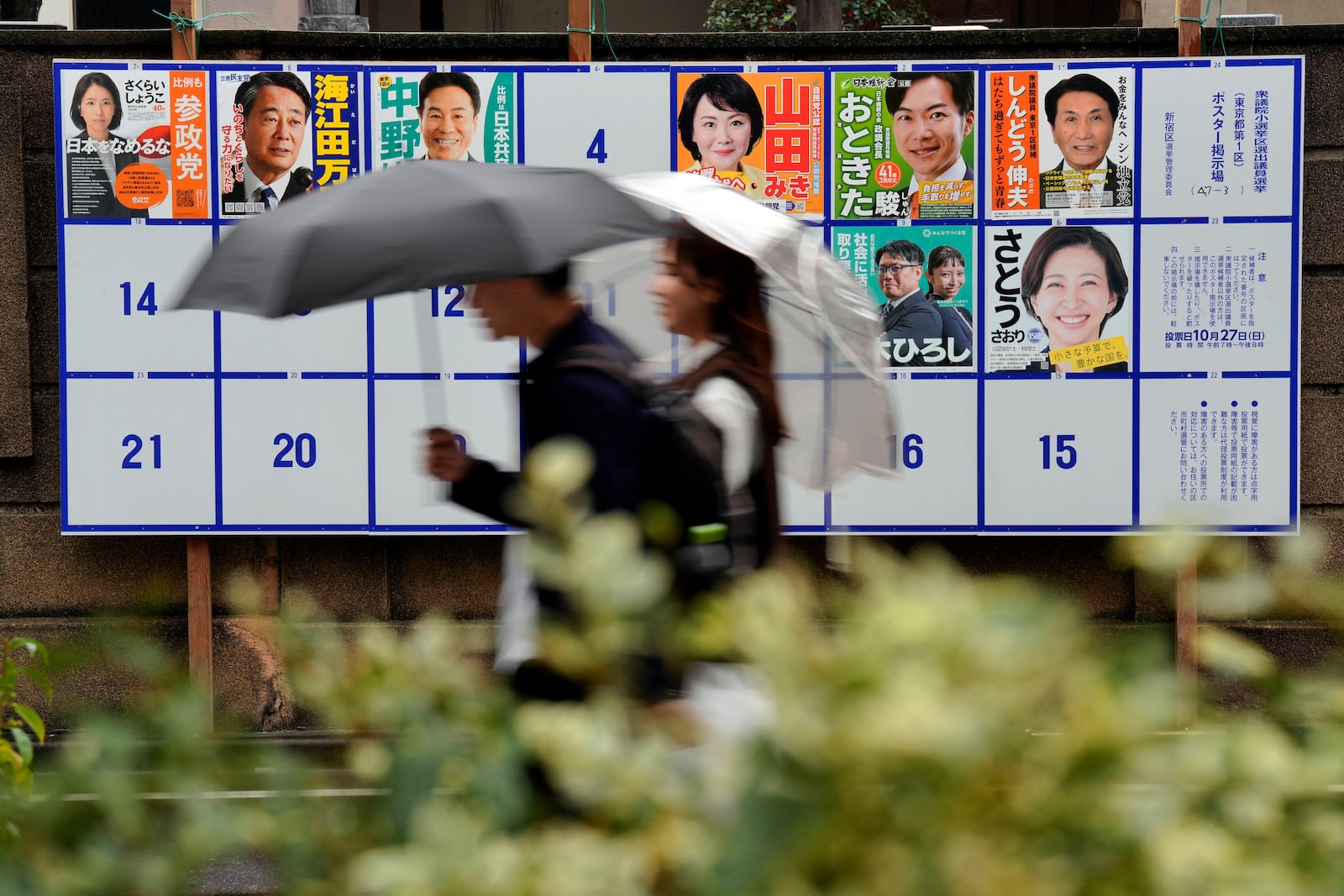 People walk past an election poster board for lower house election in Tokyo Wednesday, Oct. 23, 2024. (AP Photo/Eugene Hoshiko)