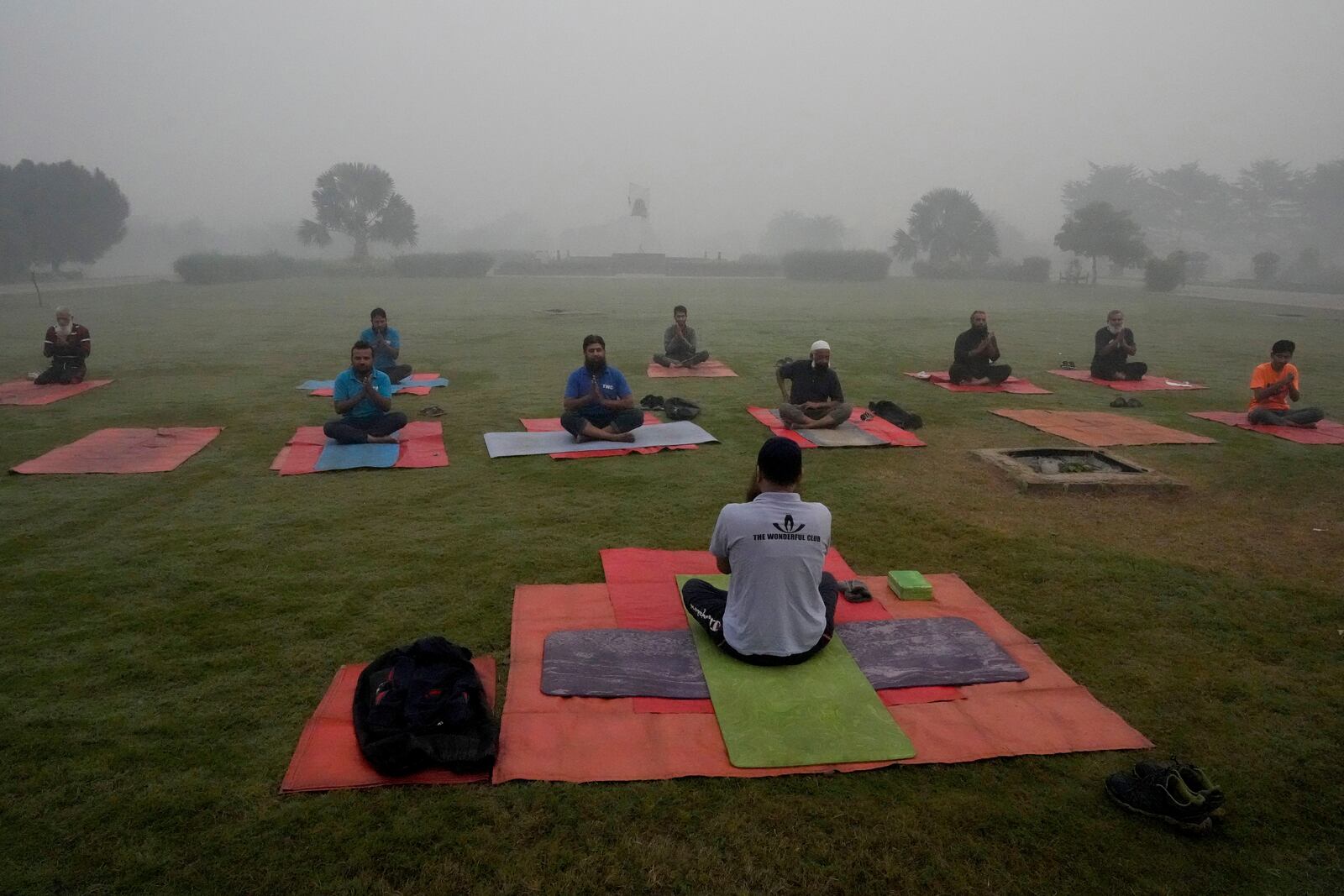 People attend their yoga class in a park as smog envelops the area of Lahore, Pakistan, Friday, Nov. 8, 2024. (AP Photo/K.M. Chaudary)