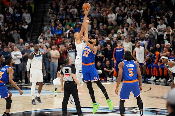 Minnesota Timberwolves center Rudy Gobert (27) and New York Knicks center Karl-Anthony Towns (32) jump during the tip-off in the first half of an NBA basketball game, Thursday, Dec. 19, 2024, in Minneapolis. (AP Photo/Abbie Parr)