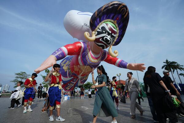 A giant balloon depicting a dancer flies over the people before a performance during the "Celebrating Cambodia" event as part of the New Year's Eve in front of Royal Palace in Phnom Penh, Cambodia, Tuesday Dec. 31, 2024. (AP Photo/Heng Sinith)