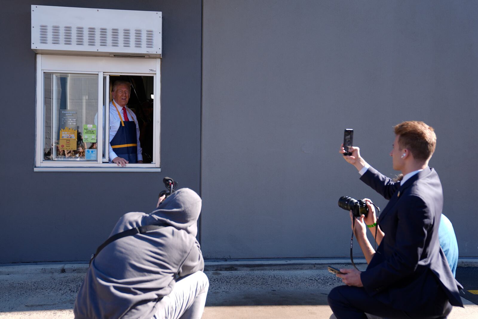 Republican presidential nominee former President Donald Trump poses for photos at a drive-thru window during a campaign stop at a McDonald's, Sunday, Oct. 20, 2024, in Feasterville-Trevose, Pa. (AP Photo/Evan Vucci)