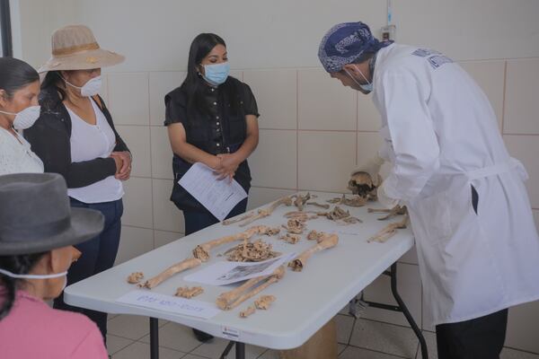 A forensic worker displays the bones of victims of Peru's internal armed conflict (1980-2000) before returning them to relatives in Ayacucho, Peru, Tuesday, Oct. 22, 2024. (AP Photo/Silvio La Rosa)