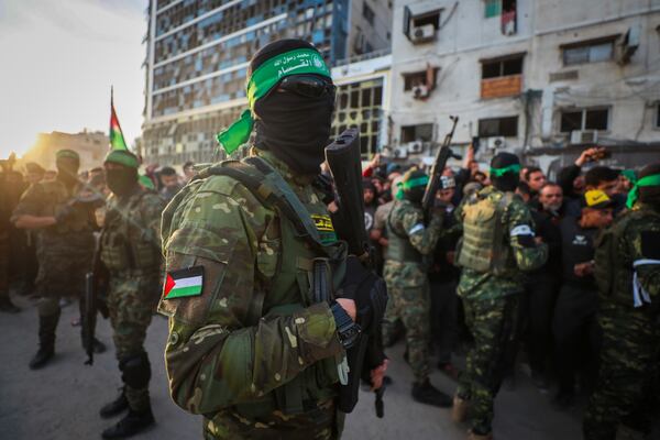 FILE - Fighters from the Qassam Brigades, the military wing of Hamas, control the crowd as Red Cross vehicles come to collect Israeli hostages under a ceasefire agreement between Israel and Hamas, in Gaza City, Jan. 19, 2025. (AP Photo/Abed Hajjar, File)