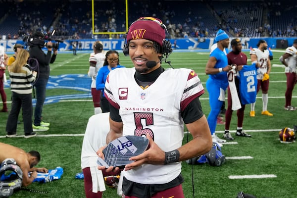 Washington Commanders quarterback Jayden Daniels (5) does an interview after an NFL football divisional playoff game against the Detroit Lions, Saturday, Jan. 18, 2025, in Detroit. (AP Photo/Seth Wenig)