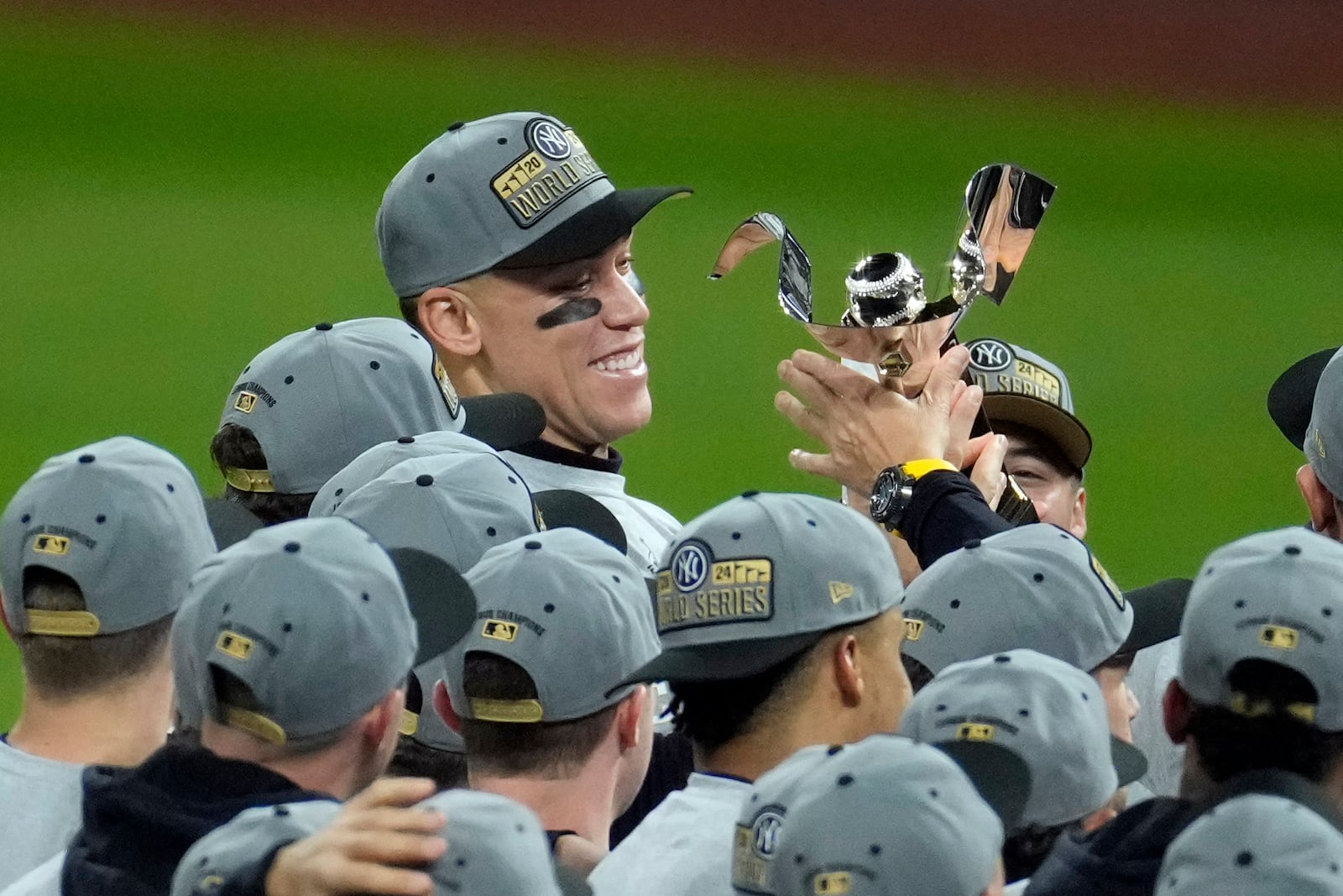 New York Yankees' Aaron Judge holds the American League Championship trophy after Game 5 of the baseball AL Championship Series against the Cleveland Guardians Sunday, Oct. 20, 2024, in Cleveland. The Yankees won 5-2 to advance to the World Series. (AP Photo/Jeff Roberson)