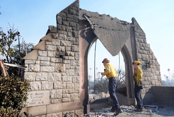 Firefighters study damage at St. Mark's Episcopal Church after it was destroyed by the Eaton Fire, Friday, Jan. 10, 2025, in Altadena, Calif. (AP Photo/Chris Pizzello)