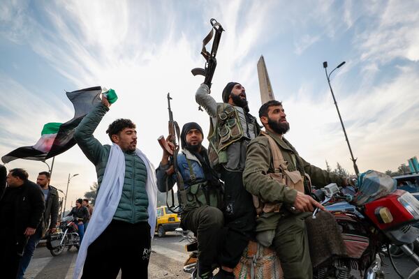 FILE - Syrian opposition fighters celebrate after the government of Bashar Assad collapses in Damascus, Syria, on Dec. 8, 2024. (AP Photo/Omar Sanadiki, File)