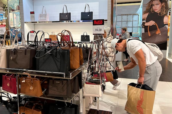 A shopper looks at handbags at Macy's department store on Sunday, Nov. 24, 2024, in New York. (AP Photo/Anne D'Innocenzio)