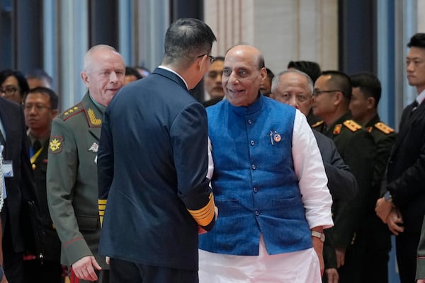 Chinese Defense Minister Dong Jun, left, shakes hand with his Indian counterpart Rajnath Singh as they arrive to attend the Association of Southeast Asian Nations (ASEAN) defense ministers' meeting in Vientiane, Laos, Thursday, Nov. 21, 2024. (AP Photo/Anupam Nath)