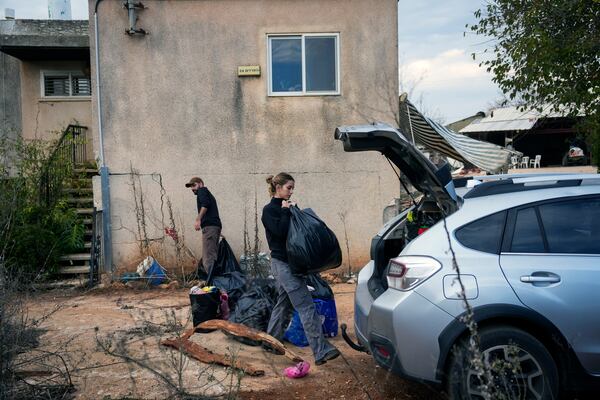 Shaked Malka, center, and her partner Yair Amar collect items from their home in Metula, Israel's northernmost town, on Wednesday, Dec. 4, 2024. Most residents of Israeli settlements and towns near the border with Lebanon have evacuated due to rocket attacks from Hezbollah in recent months.(AP Photo/Ohad Zwigenberg)