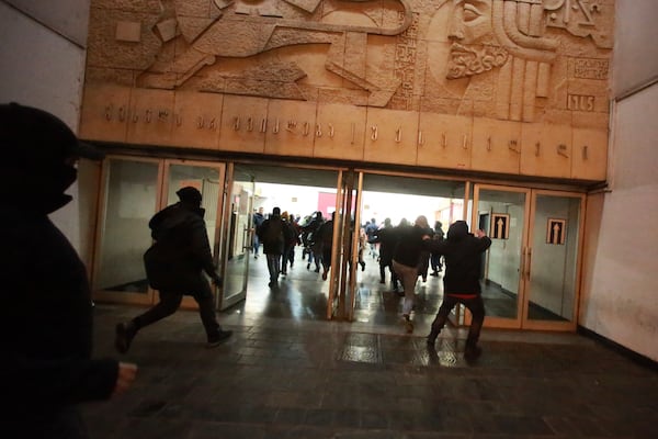 Demonstrators run to hide from the police in a subway station during a rally against the government's decision to suspend negotiations on joining the European Union for four years in Tbilisi, Georgia, Monday, Dec. 2, 2024. (AP Photo/Zurab Tsertsvadze)