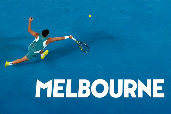 Carlos Alcaraz of Spain plays a forehand return to Novak Djokovic of Serbia during their quarterfinal match at the Australian Open tennis championship in Melbourne, Australia, Tuesday, Jan. 21, 2025. (AP Photo/Manish Swarup)