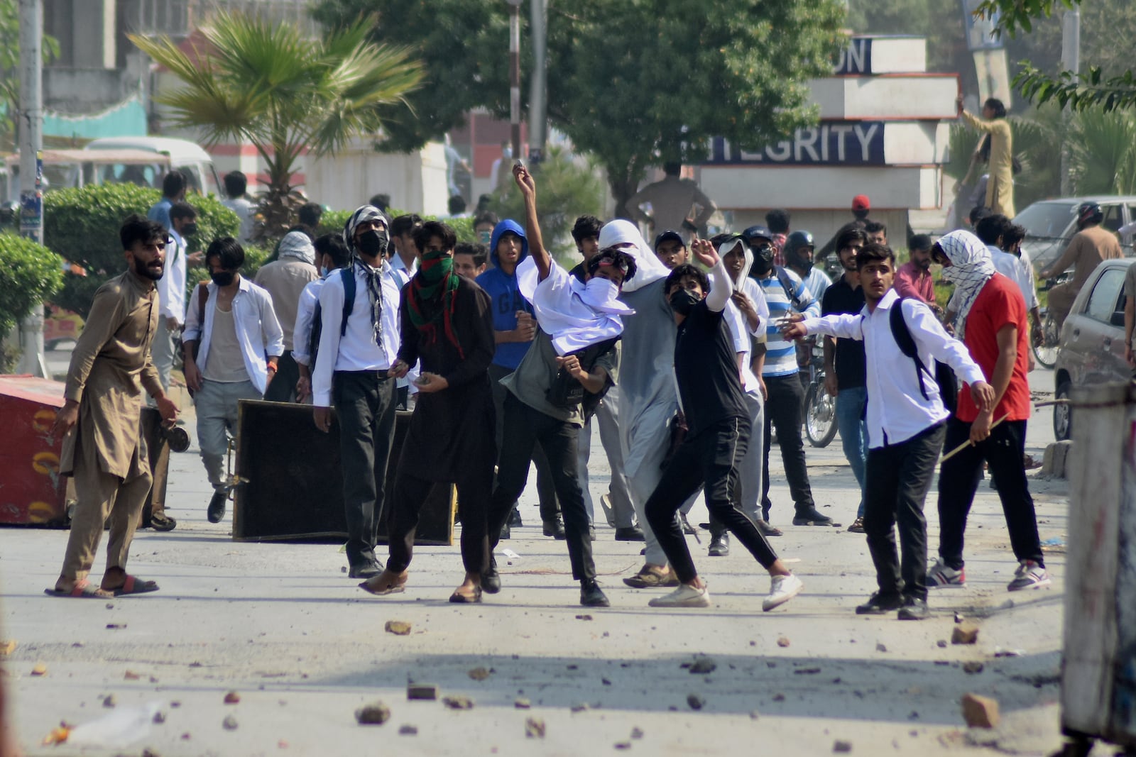 Students throw stones toward police during clashes as they protest over an alleged on-campus rape in Punjab, in Rawalpindi, Pakistan, Thursday, Oct. 17, 2024. (AP Photo/W.K. Yousafzai)