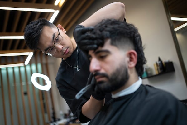 Barbers work on their clients at 12 Pell, a local barbershop in Manhattan's Chinatown, Thursday, Jan. 25, 2024, in New York. (AP Photo/John Minchillo)